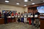 Award winners stand at board meeting.